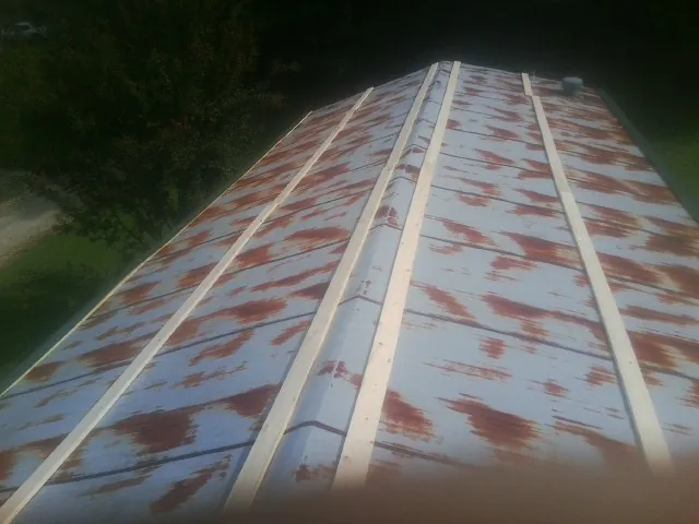 Rusted metal roof panels with new wood purlins before replacement — Storm Damage Roof Repair in Crestwood by Roofing Brothers