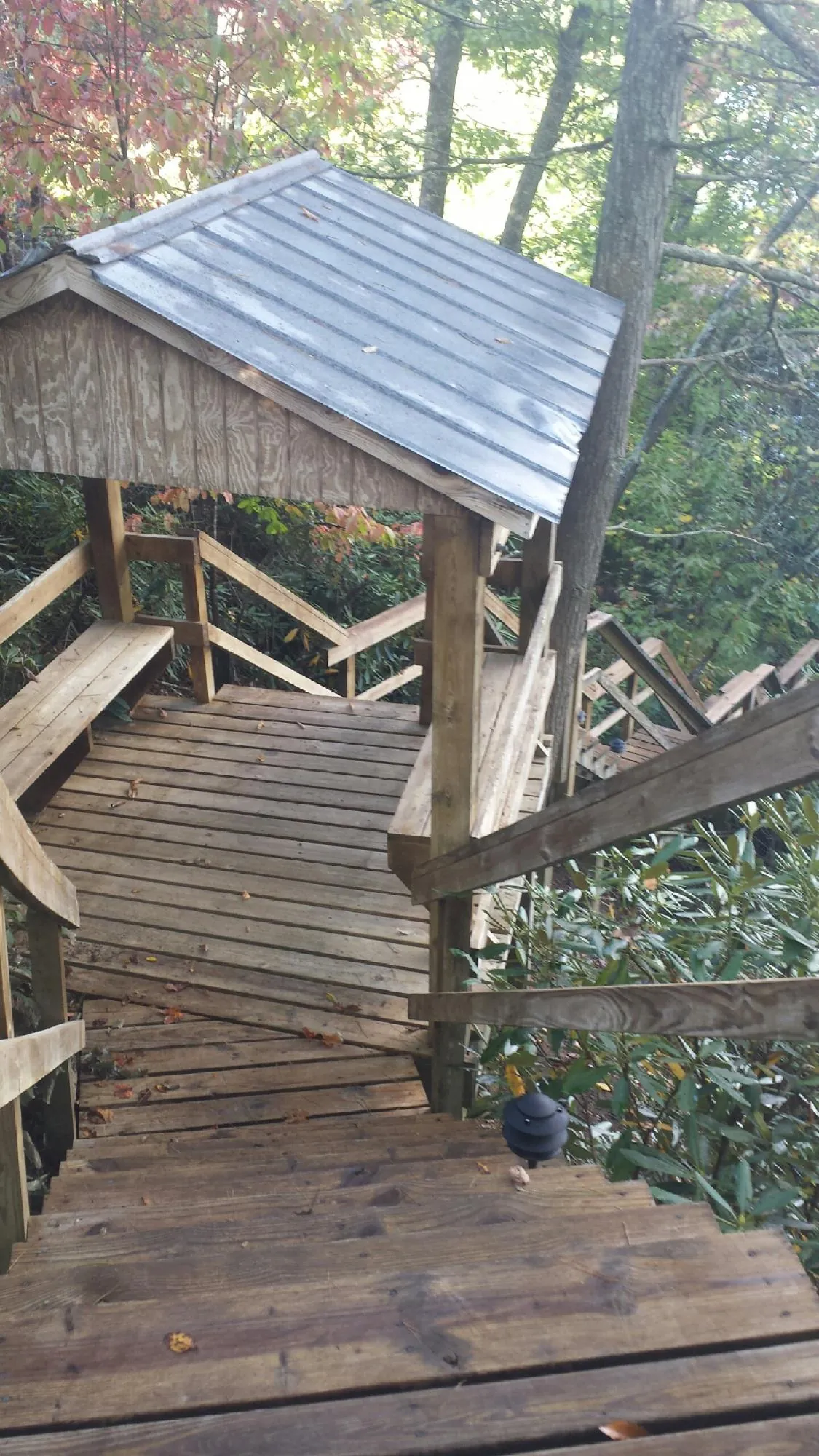 Metal roofed shelter over wooden steps on a wooded walkway — Skylight Repair & Installation work by our crew in Crestwood